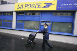 Une factrice face  un centre de tri