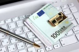Un crayon et des billets sur un clavier