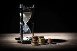 Un sablier et des pices de monnaie