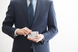 Homme en costume tenant une calculatrice