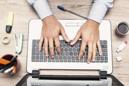 Homme tapant sur un clavier d'ordinateur