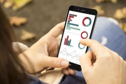 Une femme surfe sur une application mobile bancaire dans un parc