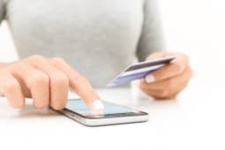 Gros plan de femme utilisant un smartphone et une carte bancaire