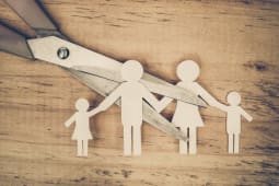 Ciseaux coupant en deux une famille de papier