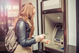 Jeune femme retirant de l'argent  un distributeur