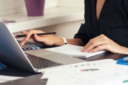 Gros plan d'une banquire faisant des calculs