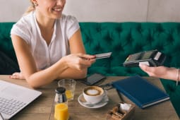 Femme payant par carte bancaire dans un caf