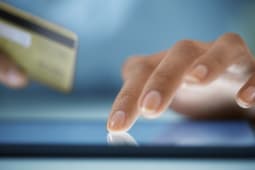 Gros plan sur les mains d'une femme achetant en ligne sur une tablette