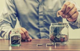 Homme qui met de l'argent dans un bocal