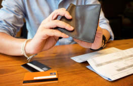 Homme fouillant un portefeuille vide