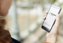 Une femme consulte l'application Fortuneo sur son smartphone