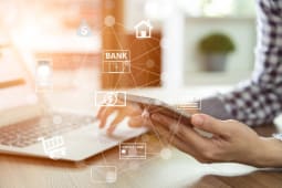 Homme consultant sa banque sur mobile et ordinateur