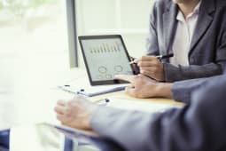 Personnes analysant un graphique sur tablette