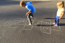 Enfants jouant  la marelle dans une cour d'cole
