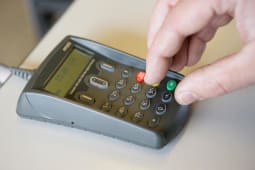 Personne entrant son code de carte bancaire sur un terminal de paiement lectronique