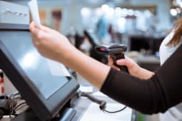 Femme scannant un article  un caisse automatique
