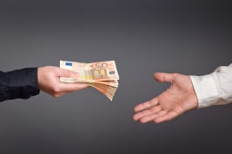 Une personne donnant des billets  une autre personne