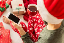 Jeune femme en bonnet de Nol consultant son smarphone