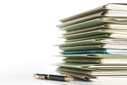 Un stylo  ct d'une pile de dossiers