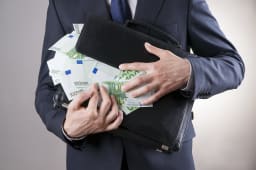 Une homme et une valise pleine de billets