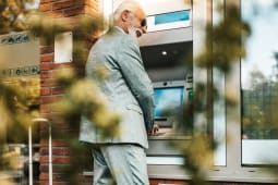 Senior qui retire de l'argent dans un distributeur