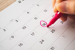personne qui entoure une date dans un calendrier