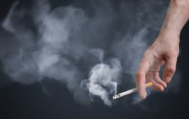 Main d'un homme tenant une cigarette allume