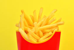 Cornet de frites rouge sur fond jaune