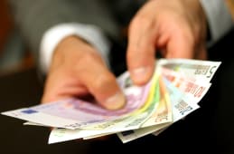 un homme tenant des billets en euros