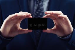 Un homme en costume prsente une carte bancaire noire