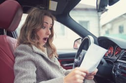 Femme lisant une facture au volant