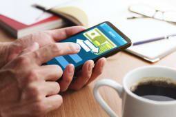 Un homme fait un virement depuis son mobile