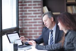 Un homme et une femme collaborent face  un ordinateur
