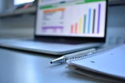 un cahier devant un ordinateur portable