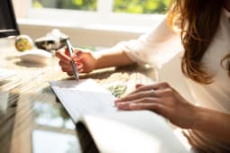 Une femme signe un chque