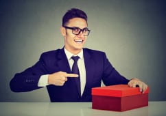 un homme pointant du doigt un cadeau