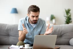 Un homme en colre devant son ordinateur portable