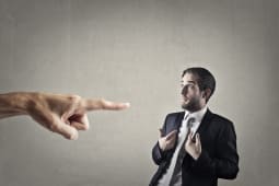Un homme en costume point du doigt