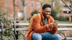Un homme utilise son smartphone dans un parc