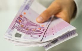 Un homme tient une liasse de billets de 500 euros