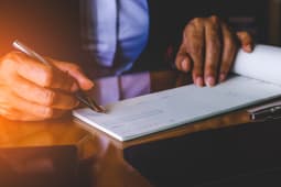 Une femme signe un chque