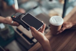 Une femme paye son caf avec un smartphone