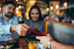 Un couple au restaurant paie sans contact par carte bancaire