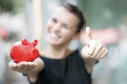 Une femme tient une tirelire dans sa main