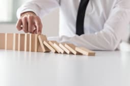 Un homme empche des dominos de chuter