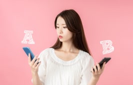 Une femme hsite entre deux tlphones mobiles