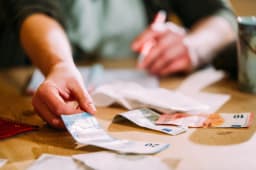 Une femme fait ses comptes et manipule des billets