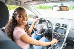Une jeune conductrice dans sa voiture.