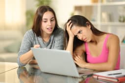 Deux jeunes femmes devant un ordinateur.