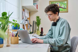 Un tudiant  son bureau, devant son ordinateur.